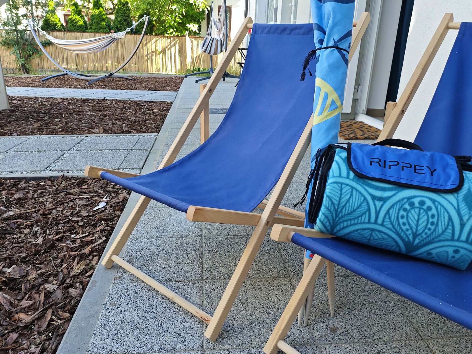 Leżaki, parasol i koc plażowy przed domem